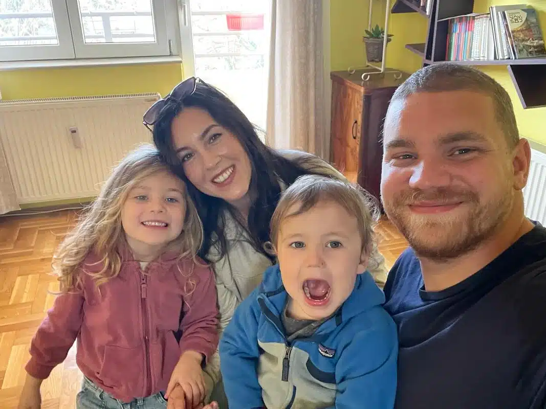 Family of 4 posing and smiling for a photo.